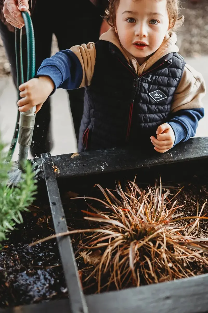 A child watering the garden at Canopy