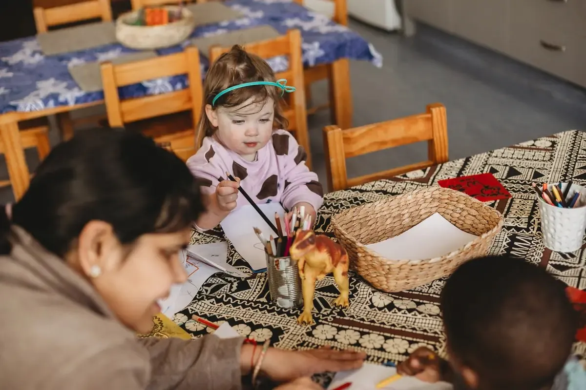 Children drawing together around a classroom table