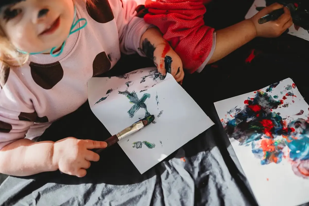Children exploring paint together at Canopy