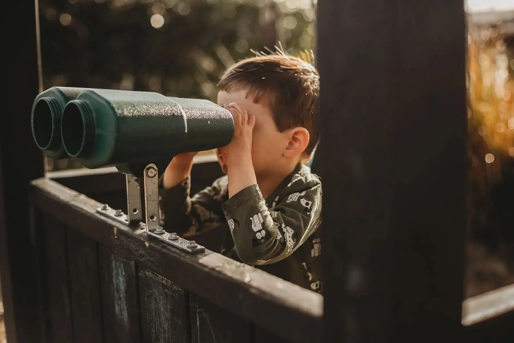 A child discovering the outdoor play telescope