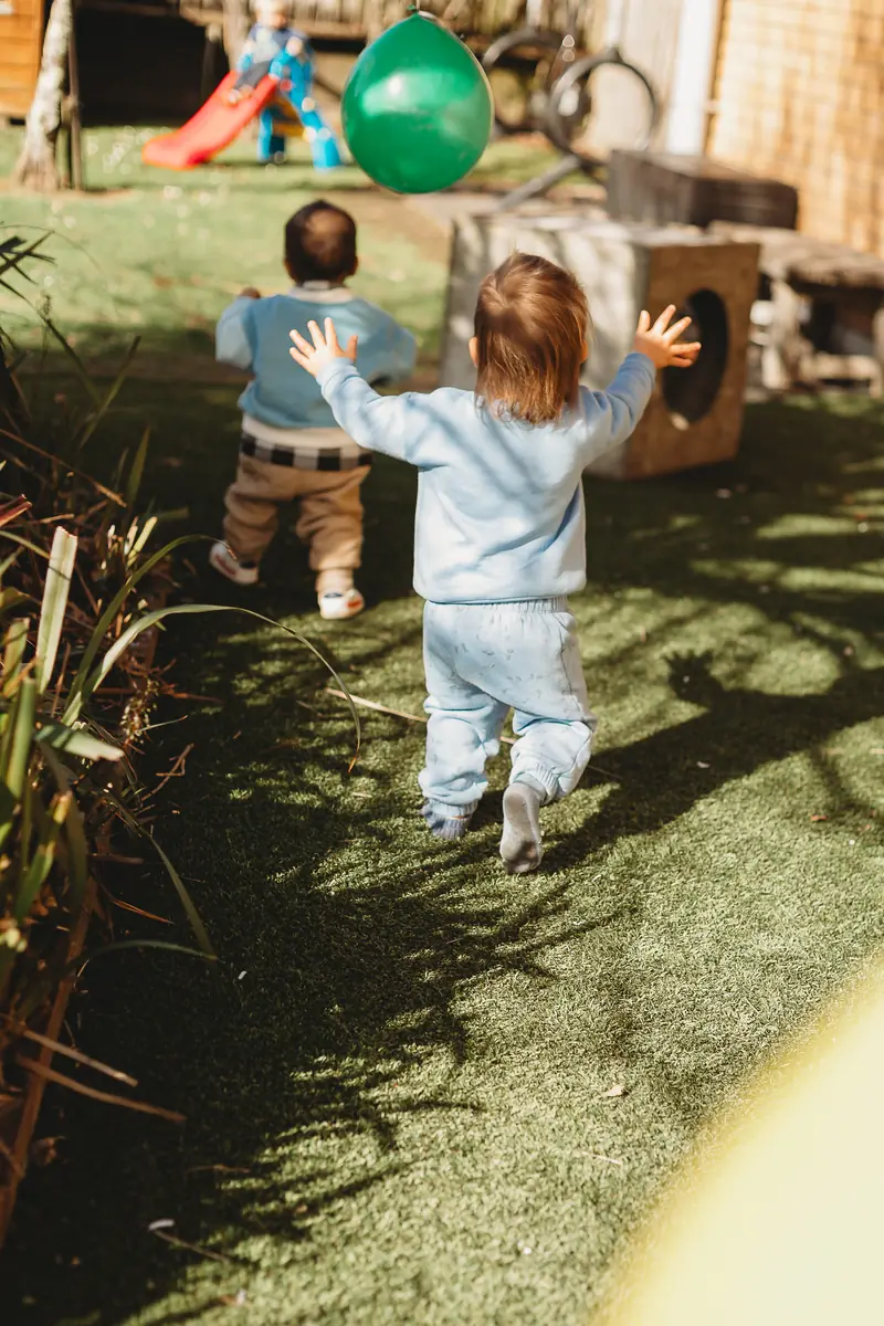 Children playing outside at Canopy, seen from behind