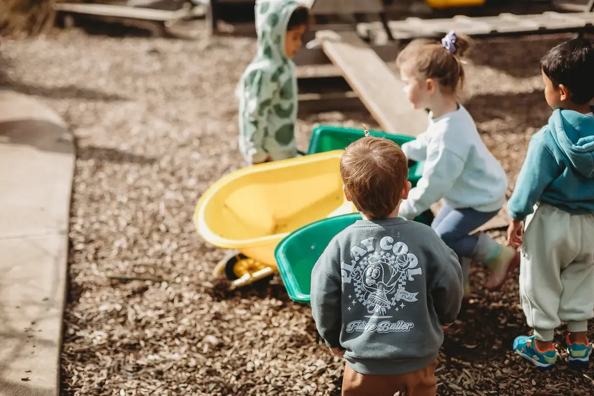 Children working together with wheelbarrows outdoors